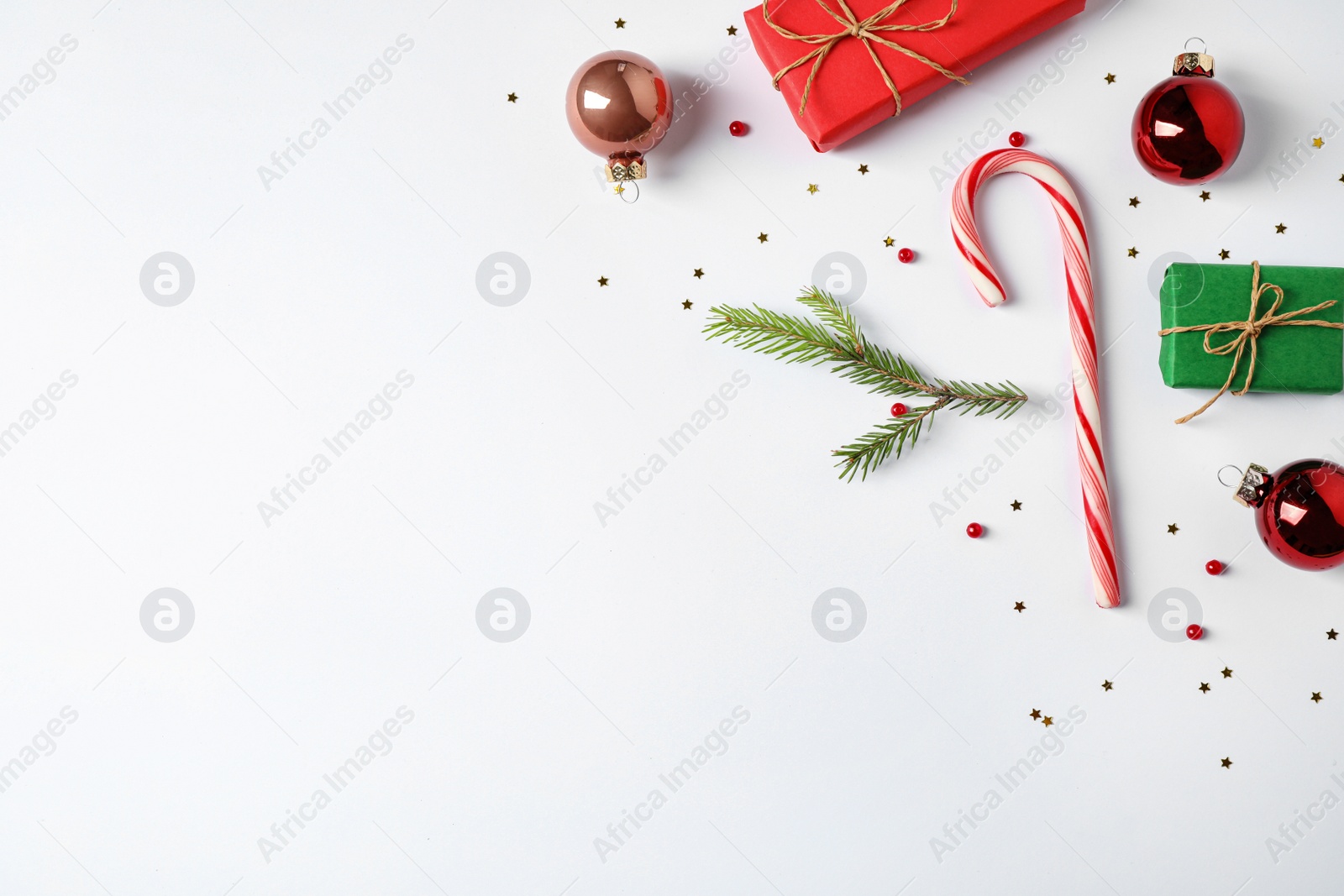 Photo of Flat lay composition with Christmas gifts and festive decor on white background. Space for text