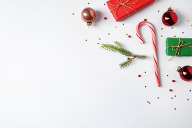 Photo of Flat lay composition with Christmas gifts and festive decor on white background. Space for text