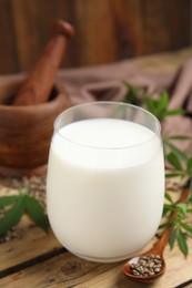 Photo of Glass of fresh hemp milk on wooden table