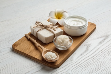 Board with Shea butter and cosmetic products on table