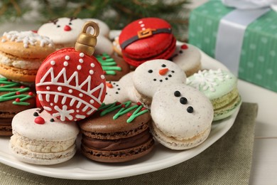 Photo of Beautifully decorated Christmas macarons on white table, closeup