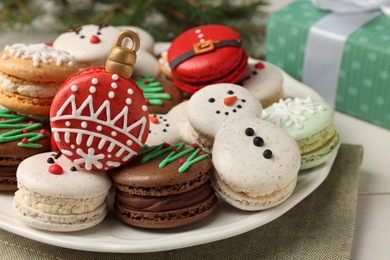 Beautifully decorated Christmas macarons on white table, closeup