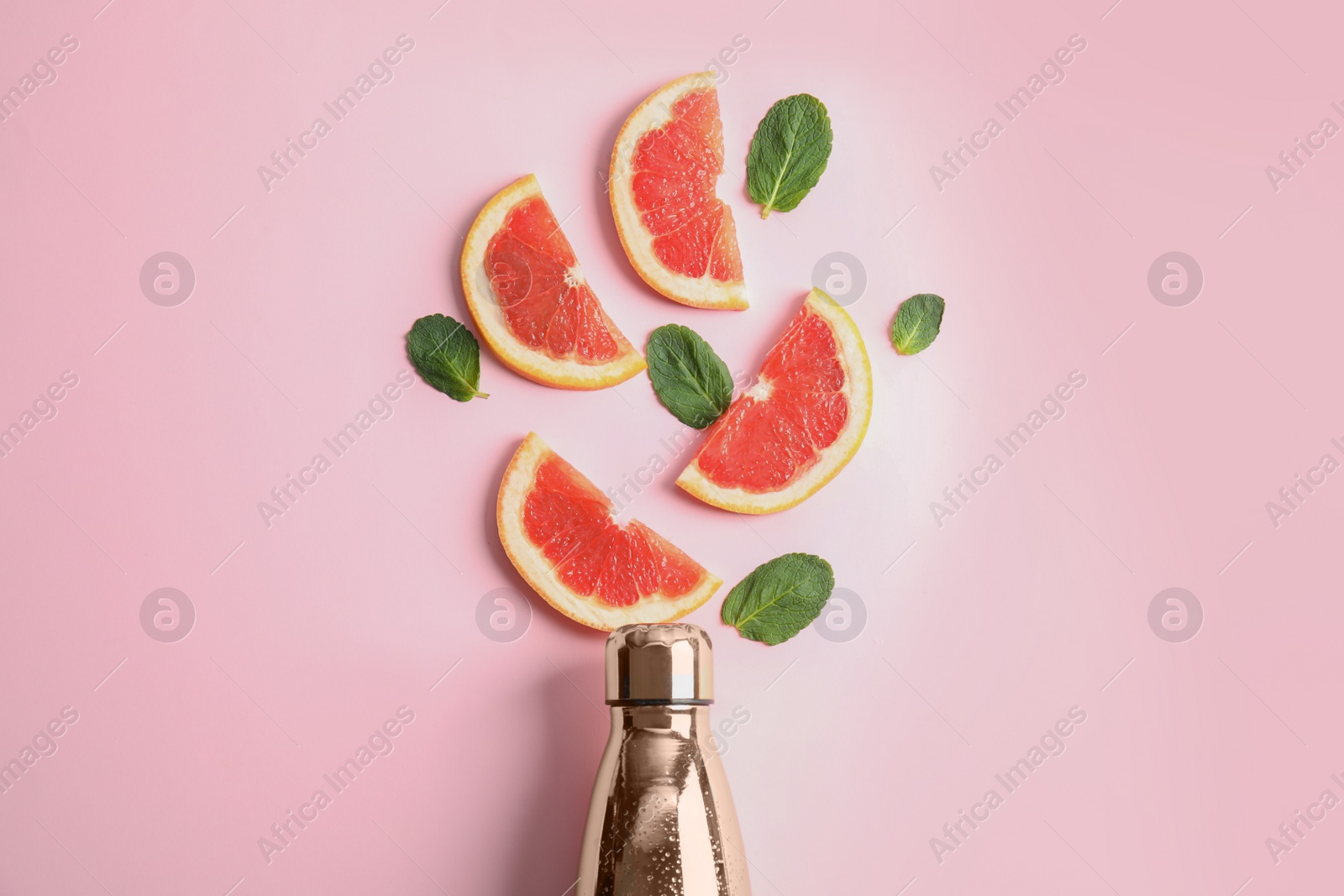 Photo of Flat lay composition with bottle, grapefruit slices and leaves on color background