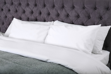 Photo of Bed with soft fluffy pillows at home