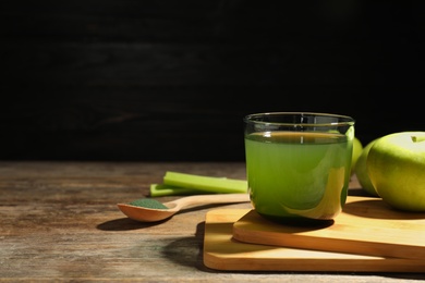 Photo of Composition with spirulina drink on table against black background. Space for text