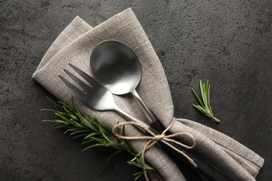 Photo of Stylish setting with cutlery and napkin on black table, top view