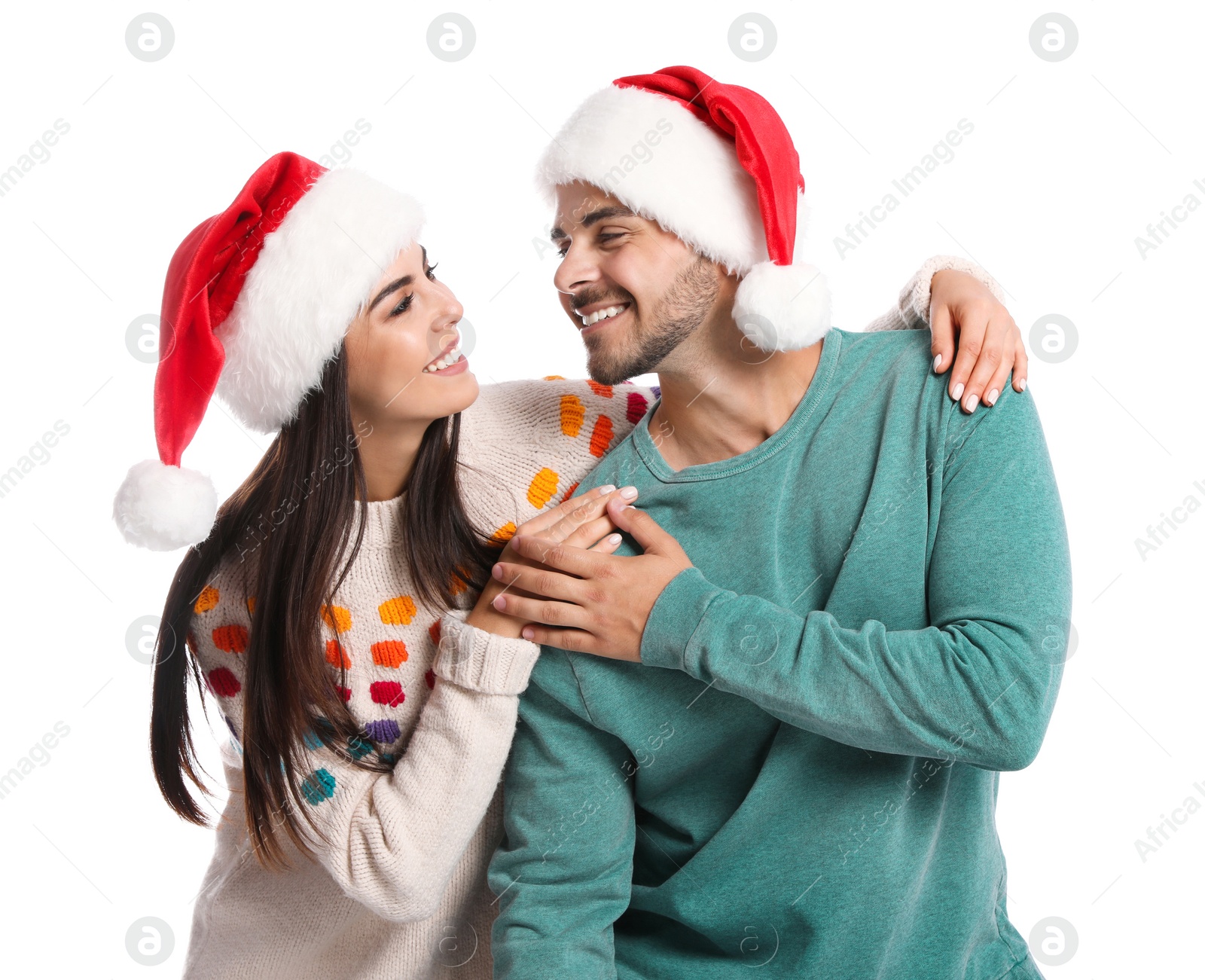 Photo of Lovely young couple in Santa hats on white background. Christmas celebration