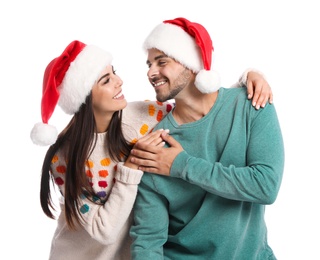 Lovely young couple in Santa hats on white background. Christmas celebration