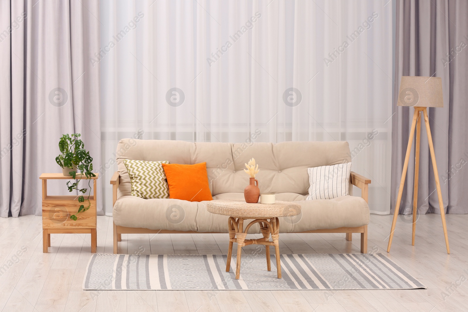 Photo of Comfortable sofa, coffee table and houseplant in stylish living room. Interior design