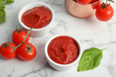 Composition with tomato sauce in bowls on table