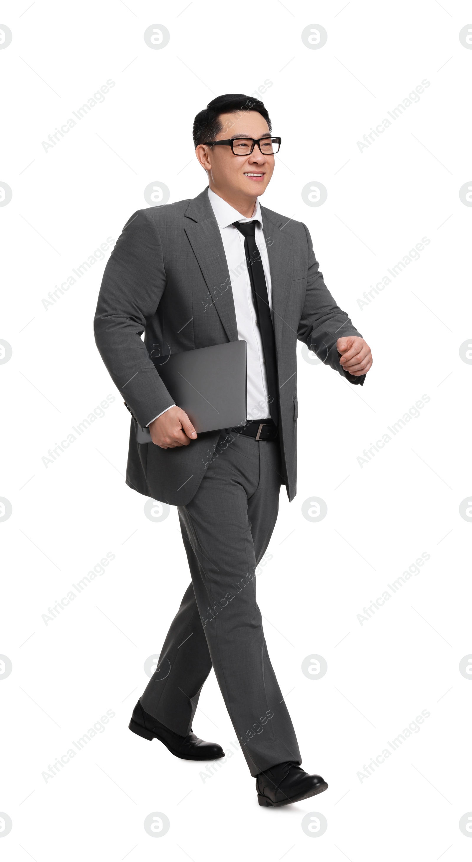 Photo of Businessman in suit with laptop walking on white background