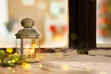 Image of Lantern with candle and fir branches near window outdoors. Christmas eve