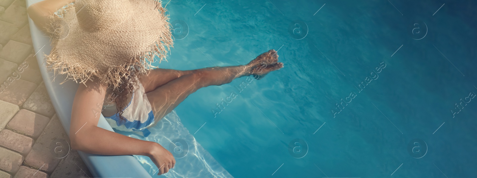 Image of African American woman resting in outdoor swimming pool on sunny day, banner design