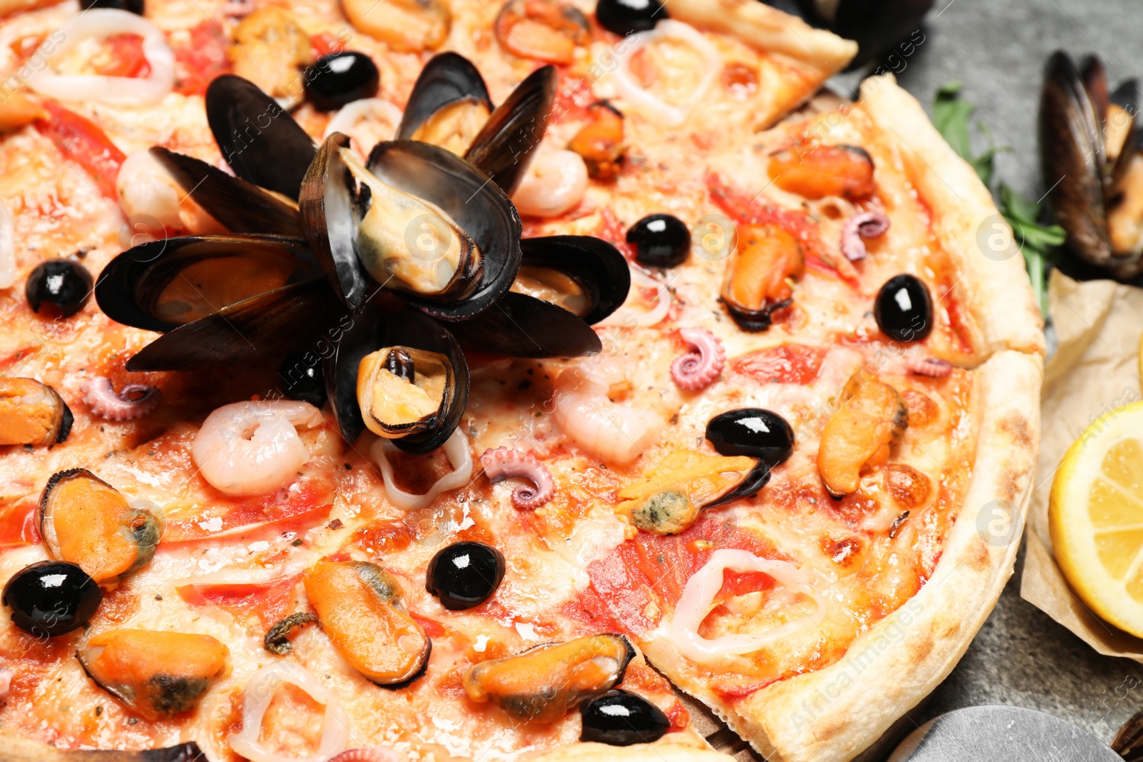 Photo of Tasty fresh pizza with seafood on table, closeup