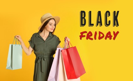 Image of Black Friday Sale. Beautiful young woman with shopping bags on yellow background