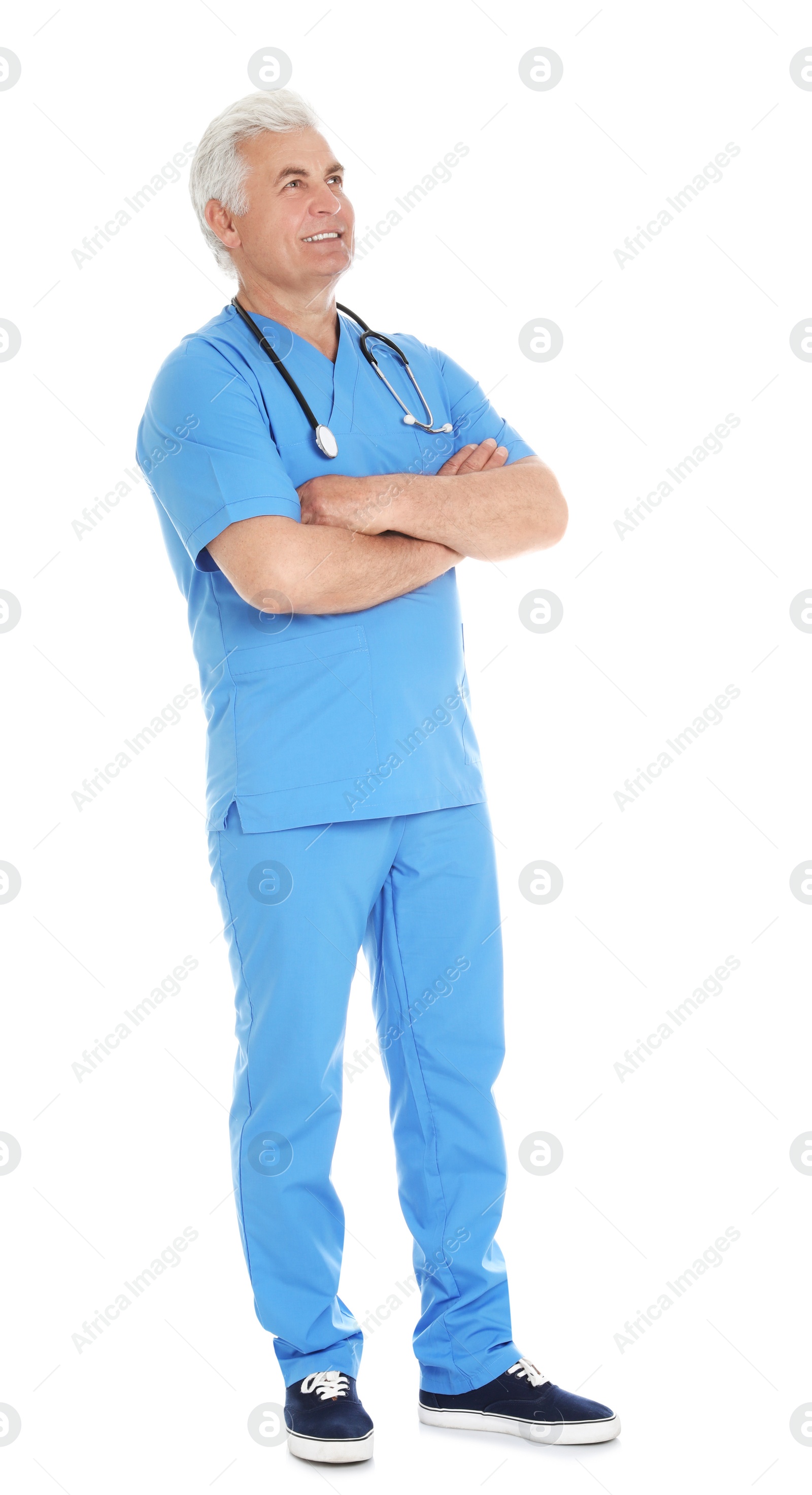 Photo of Full length portrait of male doctor in scrubs with stethoscope isolated on white. Medical staff