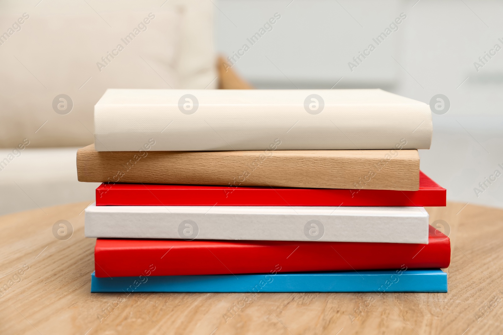 Photo of Stack of hardcover books on wooden table indoors