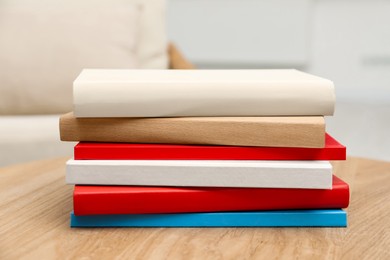 Photo of Stack of hardcover books on wooden table indoors