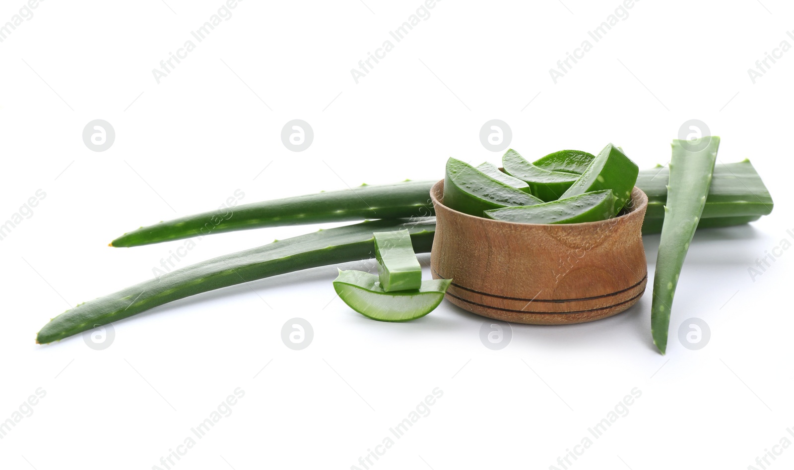 Photo of Bowl with pieces of aloe vera and green leaves on white background