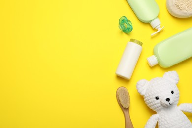 Photo of Flat lay composition with baby cosmetic products on yellow background, space for text