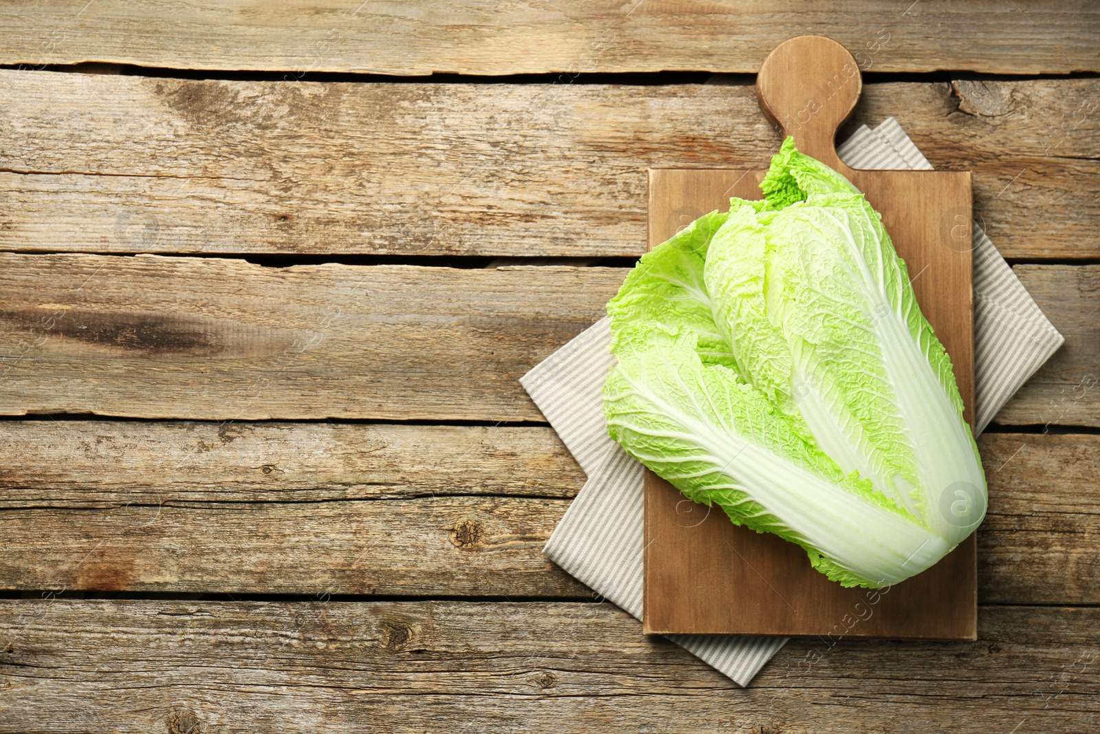 Photo of Fresh ripe Chinese cabbage on wooden table, top view. Space for text