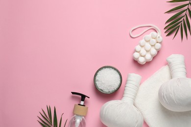 Beautiful spa composition with herbal massage bags and different care products on pink background, flat lay. Space for text