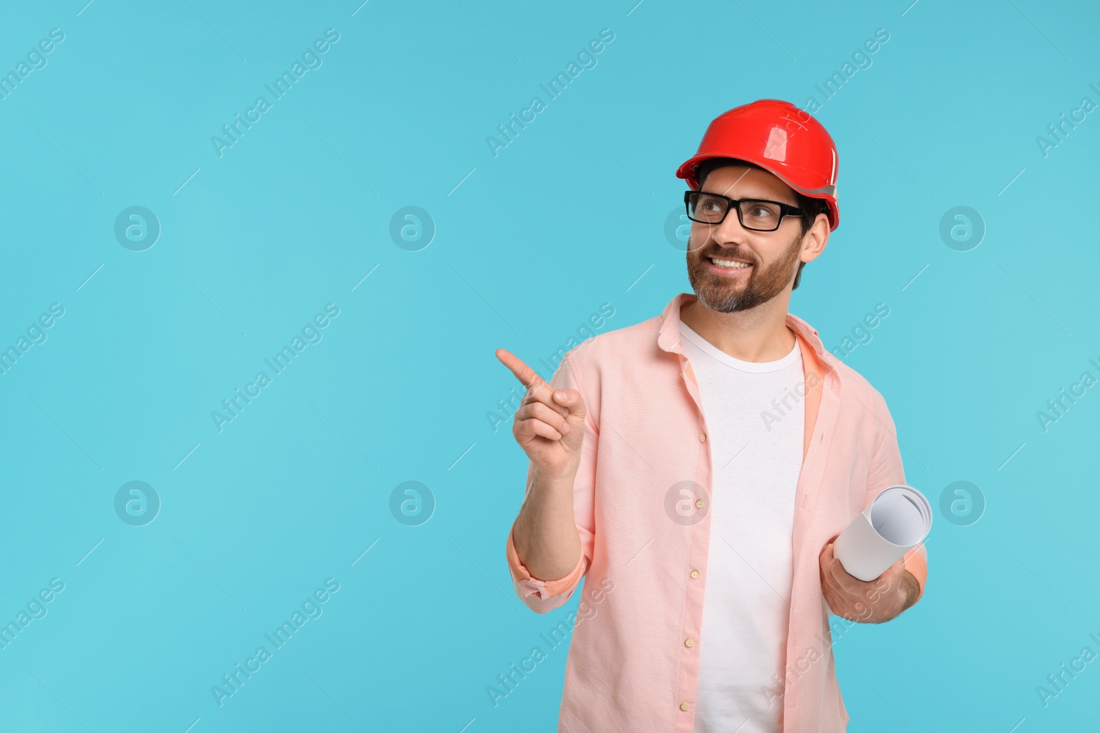 Photo of Architect in hard hat with draft pointing at something on light blue background, space for text