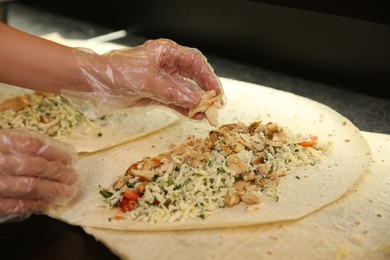 Photo of Chef cooking shawarma at black table, closeup