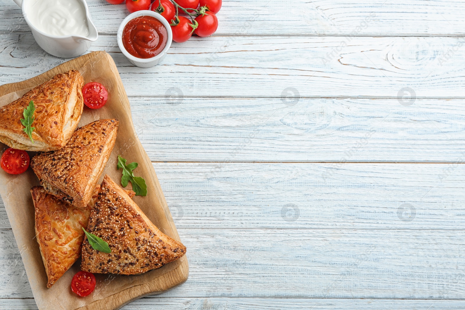 Photo of Flat lay composition with fresh delicious puff pastry on white wooden table. Space for text