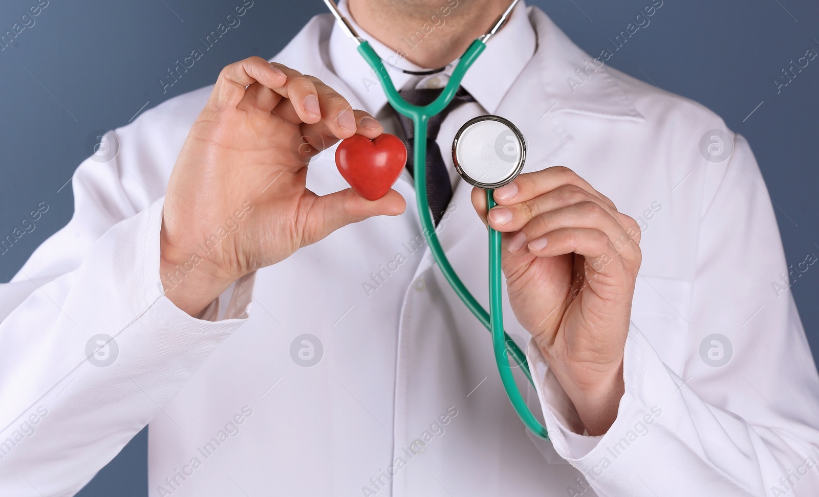 Photo of Doctor holding heart and stethoscope, closeup. Prevent heart attack