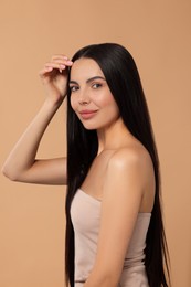 Beautiful woman with long hair on beige background