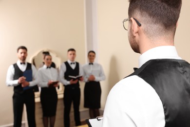Group of people attending professional butler courses in hotel, space for text