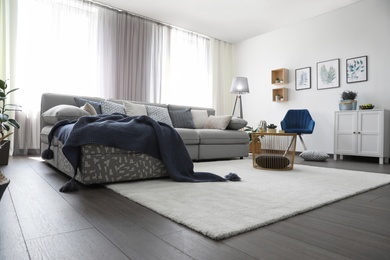 Photo of Elegant living room with comfortable sofa near windows. Interior design