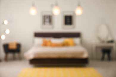 Blurred view of stylish room interior with comfortable bed