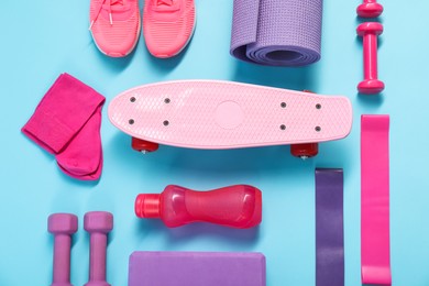 Different sports equipment on light blue background, flat lay