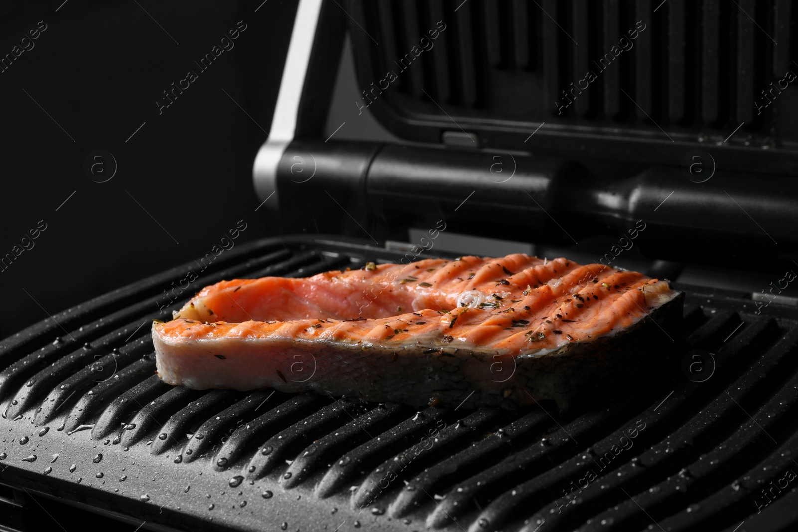 Photo of Cooking salmon. Grill with tasty fish steak and spices