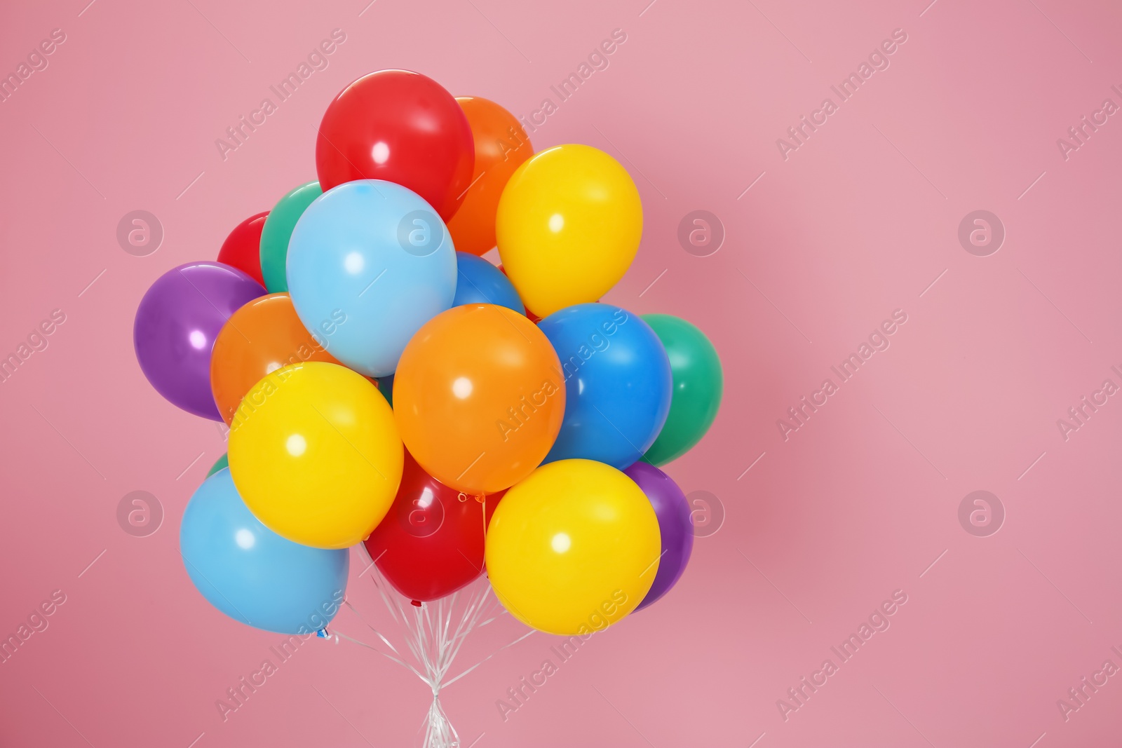 Photo of Bunch of bright balloons and space for text against color background