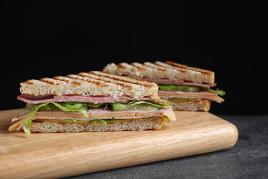 Photo of Tasty sandwich with ham on grey table