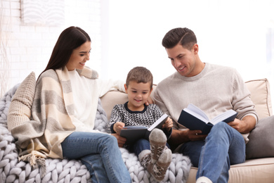 Photo of Happy family with little son reading books at home. Winter vacation