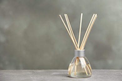 Aromatic reed freshener on table against grey background