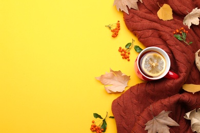 Photo of Flat lay composition with hot drink on yellow background, space for text. Cozy autumn