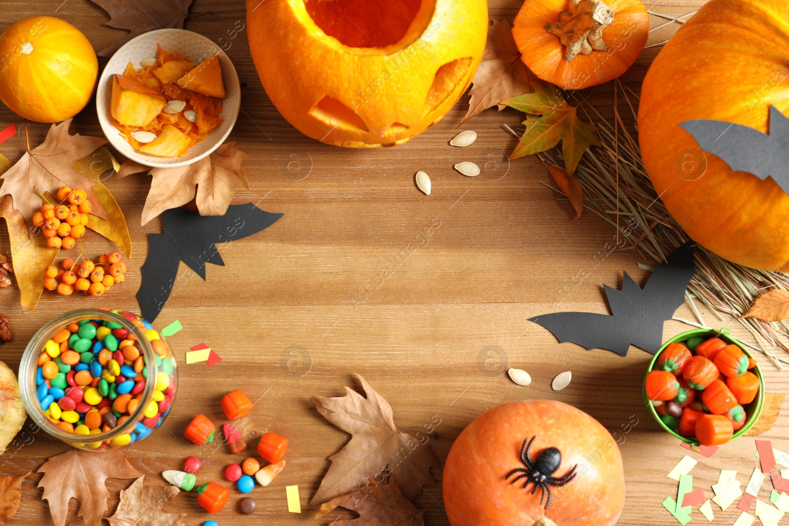 Photo of Halloween pumpkin head jack lantern and holiday decorations on wooden table, flat lay composition with space for text