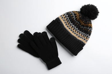 Woolen gloves and hat on white background, flat lay