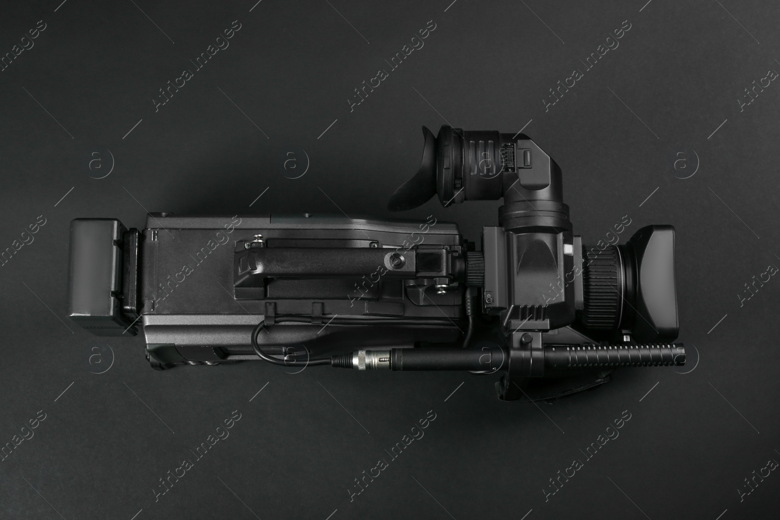Photo of Modern video camera on black background, top view