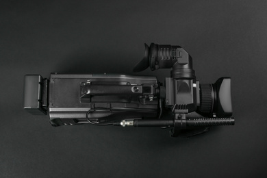 Modern video camera on black background, top view