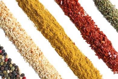 Rows of different aromatic spices on white background, top view
