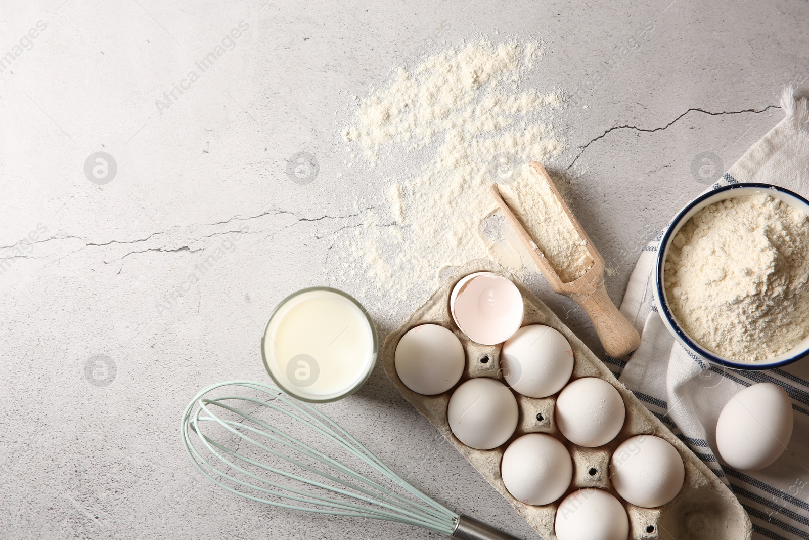 Photo of Making dough. Flour, eggs, milk and tools on light textured table, flat lay. Space for text