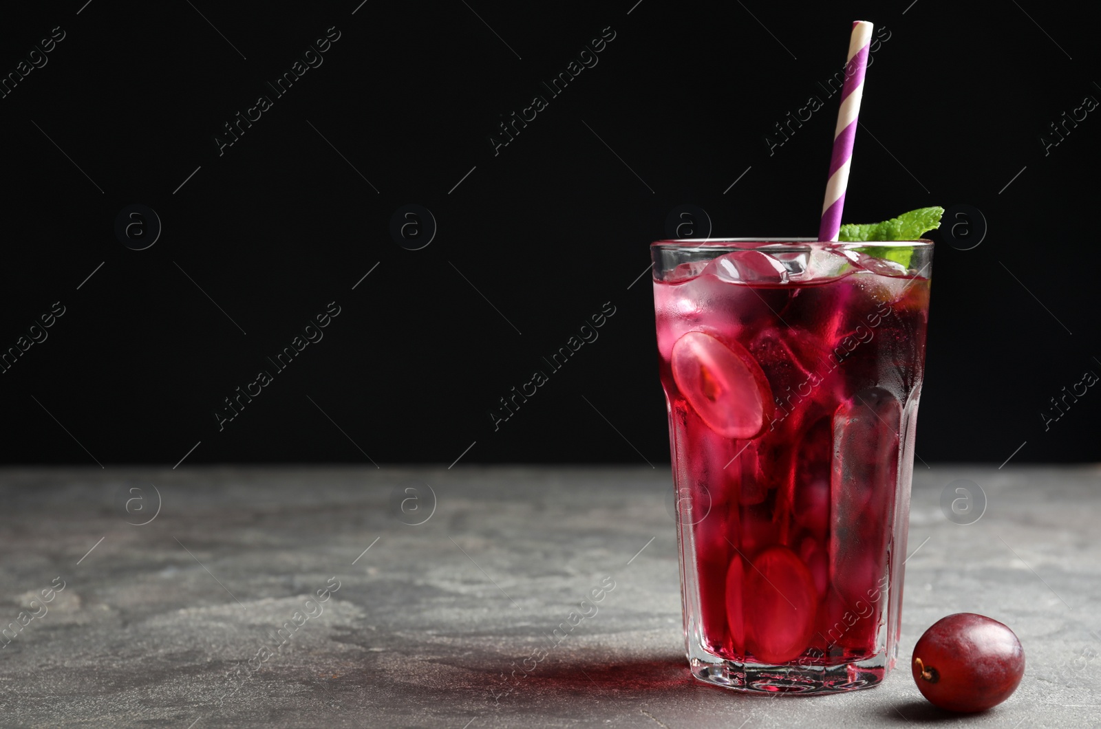 Photo of Delicious grape soda water on grey table, space for text. Refreshing drink