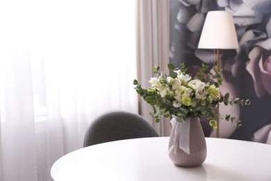 Photo of Vase with beautiful bouquet on white table indoors, space for text. Stylish interior element