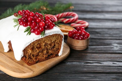 Photo of Traditional Christmas cake on black wooden table, space for text. Classic recipe